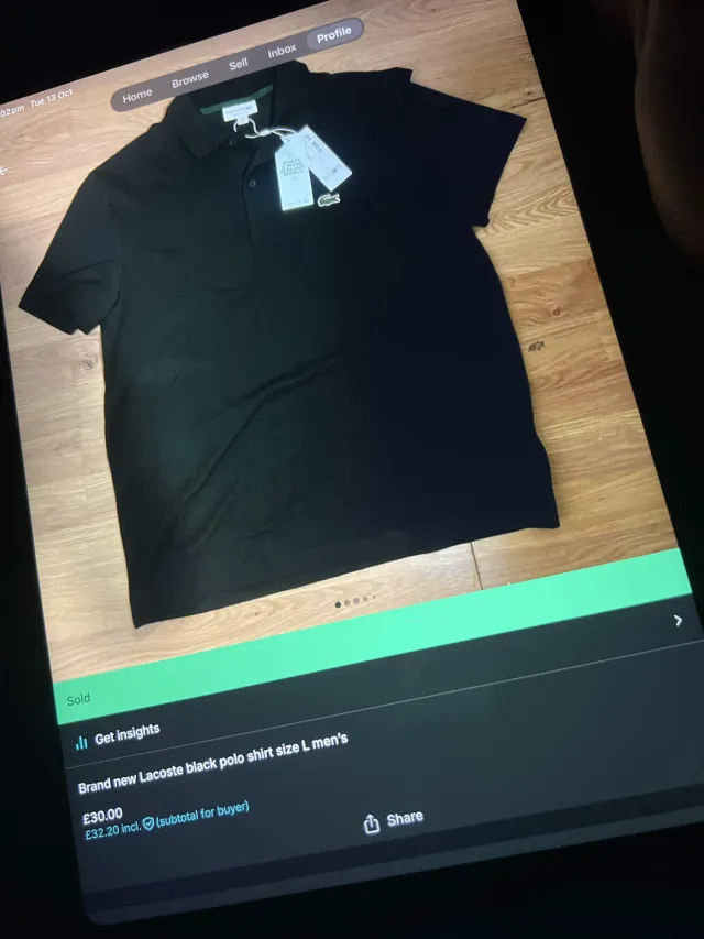 A brand new Lacoste black polo shirt listed on Vinted, on a tablet screen