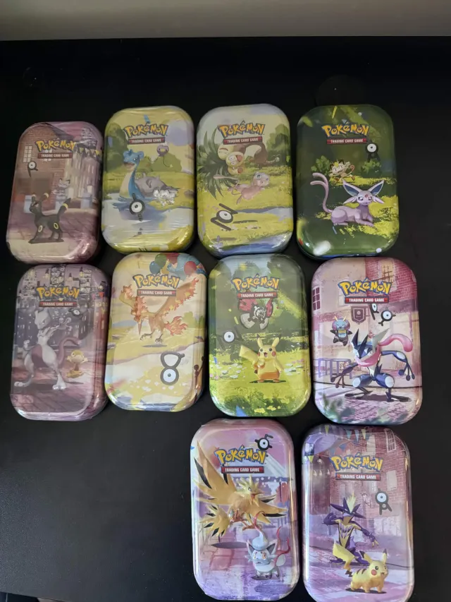 Eleven sealed Pokémon mini tins laid out on a table